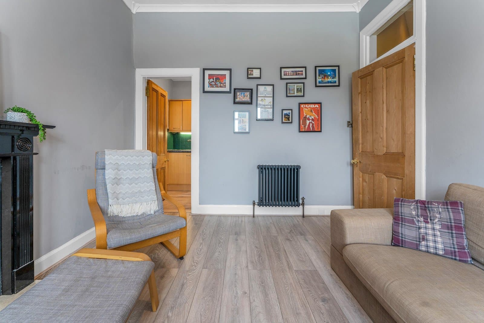 The living room from the bay window, with the fireplace on the left and the kitchen through the far door